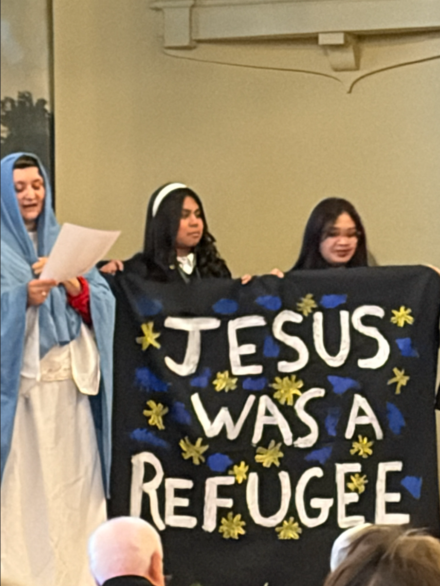 Advocates holding a banner that reads “Jesus was a refugee”